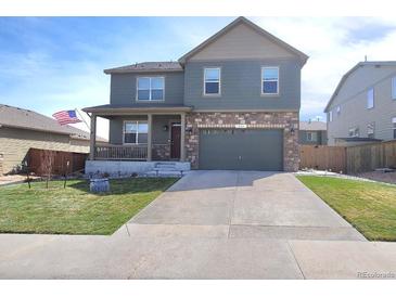 Charming two-story home featuring a cozy front porch and a well-manicured lawn, showcasing curb appeal at 7888 E 139Th Pl, Brighton, CO 80602