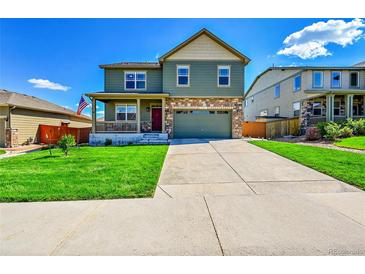 Charming two-story home with a covered porch, stone accents, and well-maintained landscaping at 7888 E 139Th Pl, Brighton, CO 80602