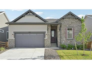Charming home featuring a stone and siding facade, with a two-car garage and beautifully landscaped front yard at 5905 S Platte Canyon Dr, Littleton, CO 80123