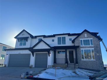 Two-story craftsman home with gray and white exterior, two-car garage, and stone accents at 4874 Coal Bank Dr, Castle Rock, CO 80104