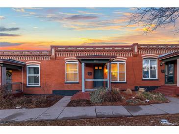 Charming brick home with a cozy front porch and inviting curb appeal at sunset at 1235 31St St, Denver, CO 80205