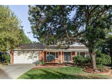 Brick ranch house with attached garage and mature landscaping at 7154 S Hudson Cir, Centennial, CO 80122