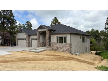 Charming single-story home with stone accents, gray siding, and a well-manicured front yard at 6152 Powell Rd, Parker, CO 80134