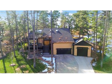 Stunning home exterior with a three-car garage and a lush, tree-filled yard at 5567 Irish Pat Murphy Dr, Parker, CO 80134