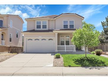 Charming two-story home featuring a spacious front porch and a well-manicured lawn with mature tree at 2354 Cactus Bloom Ct, Castle Rock, CO 80109