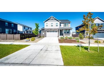 Beautiful two-story home featuring stone accents, a welcoming front porch, and well-manicured lawn at 129 S Waterloo St, Aurora, CO 80018