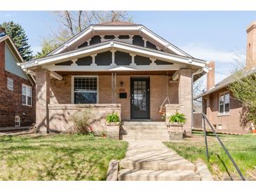 Charming brick home with a well-manicured lawn and welcoming front porch with a swing at 1061 Adams St, Denver, CO 80206