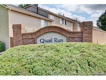 Quail Run brick community sign surrounded by greenery, offering a serene welcome to residents and visitors alike at 18234 E Arizona Ave # E, Aurora, CO 80017