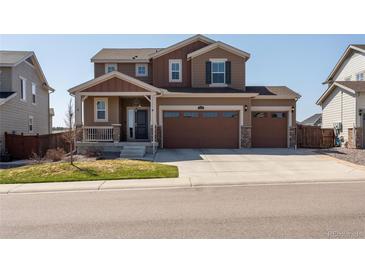 Inviting two-story home boasts a three car garage, manicured lawn, and charming front porch at 1334 Barberry Trl, Elizabeth, CO 80107
