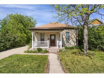 Charming single-story home featuring a cozy front porch, a well-maintained lawn and traditional architectural details at 2415 Chase St, Edgewater, CO 80214