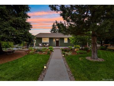 Charming single-story home with a landscaped front yard, walkway, and cozy front porch seating area at 403 Anderson St, Castle Rock, CO 80104