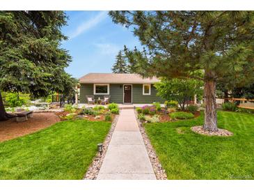Charming one story home featuring a lush, landscaped front yard, front porch, and walkway at 403 Anderson St, Castle Rock, CO 80104