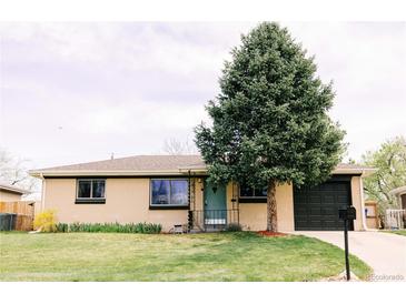Charming brick home featuring a well-maintained lawn and an eye-catching evergreen tree at 3890 Moore St, Wheat Ridge, CO 80033