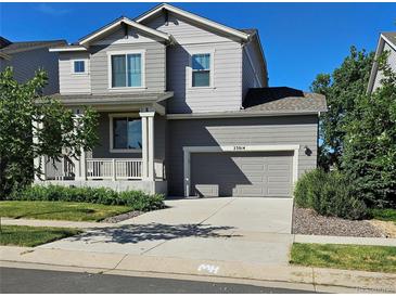 Charming two-story home featuring a covered porch, attached two-car garage, and a well-maintained front yard at 23014 Milford Ln, Parker, CO 80138