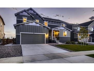 Charming two-story home boasts a gray exterior, two-car garage, and well-manicured lawn at 38 Morgan Cir, Erie, CO 80516