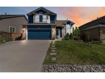 Charming two-story home with a well-manicured lawn, stepping stones, and a two-car garage at 9546 High Cliffe St, Highlands Ranch, CO 80129