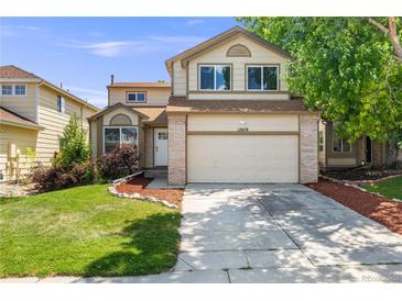 Charming two-story home with a two-car garage and well-maintained landscaping on a sunny day at 12678 W Dorado Pl, Littleton, CO 80127
