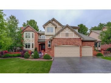 Charming two-story brick home with a well-manicured lawn and a spacious three-car garage at 11904 W Auburn Dr, Denver, CO 80228