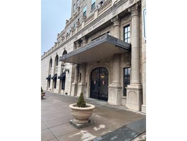 Elegant building entrance featuring ornate columns and ironwork, plus a landscaped planter at 475 W 12Th Ave # 4E, Denver, CO 80204