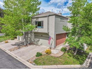 Charming two-story home with a two-car garage, inviting front yard, and mature shade trees at 766 Chimney Creek Dr, Golden, CO 80401