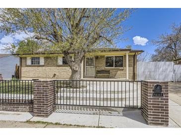 Charming brick home with a well-manicured front yard and a gated entryway at 12333 Edwards Pl, Denver, CO 80239