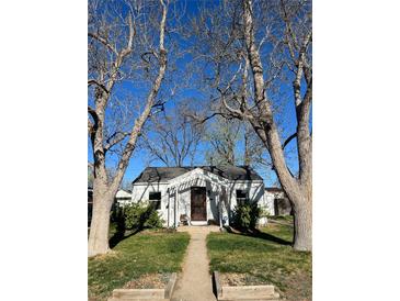Charming single-story home with a cozy front yard framed by mature trees on a sunny day at 3910 S Grant St, Englewood, CO 80113