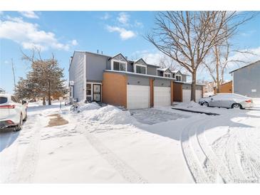 Snow covered exterior of a two-story townhome with attached garage at 1693 Carr St # A, Lakewood, CO 80214