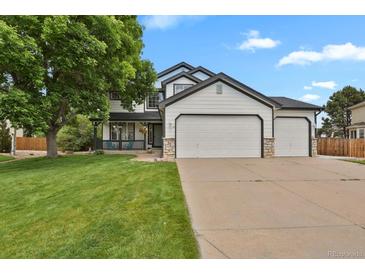Beautiful two-story home featuring a three-car garage and lush front lawn at 17303 E Dewberry Cir, Parker, CO 80134