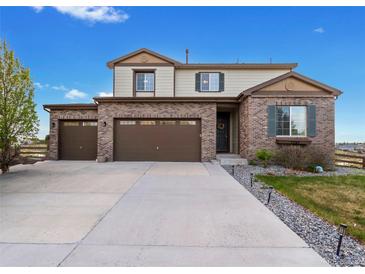 Charming two-story home featuring a three-car garage, brick facade, landscaped yard and inviting front door at 7207 S Scottsburg Way, Aurora, CO 80016