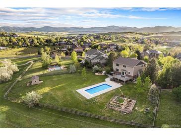 Expansive backyard with a pool, garden, shed, and view of the mountains in the distance at 7624 Russell Ct, Arvada, CO 80007
