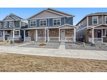 Attractive two-story home highlighting a stone facade, a welcoming porch, and a well-kept front yard at 22384 E 6Th Pl, Aurora, CO 80018