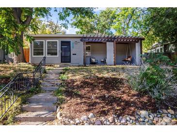 Charming one-story home featuring a covered porch swing, xeriscaping, and inviting curb appeal at 4921 Beach Ct, Denver, CO 80221