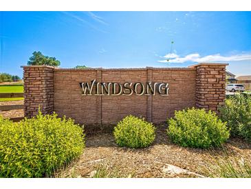 A stone 'Wind Song' community sign with manicured landscaping on a sunny day at 6187 E 155Th Pl, Thornton, CO 80602