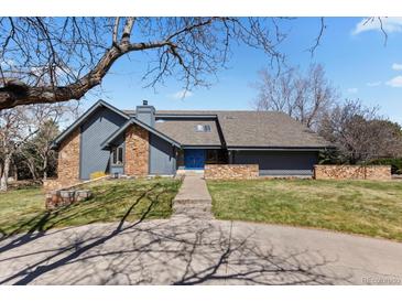 Contemporary home with stone accents, blue front door and lush front lawn at 9505 Poundstone Pl, Greenwood Village, CO 80111