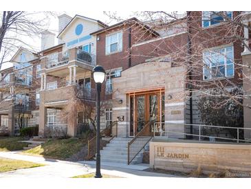 Attractive brick and stone condo building featuring balconies and well-maintained landscaping at 111 S Monroe St # B104, Denver, CO 80209