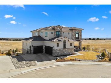 Stunning two-story stucco home with a three-car garage and beautifully landscaped front yard on a bright, sunny day at 15322 Irving Ct, Broomfield, CO 80023