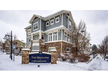 Gray exterior of townhome with stone accents, in a snow covered community at 9381 Ashbury Cir # 102, Parker, CO 80134