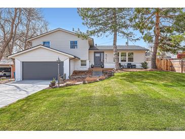 Charming two-story home with well-manicured lawn, gray trim, and attached garage at 6472 W Brittany Pl, Littleton, CO 80123