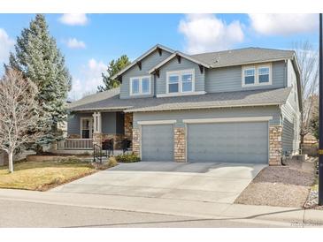 Charming two-story home featuring a three-car garage, stone accents, and inviting front porch at 448 Winterthur Cir, Highlands Ranch, CO 80129