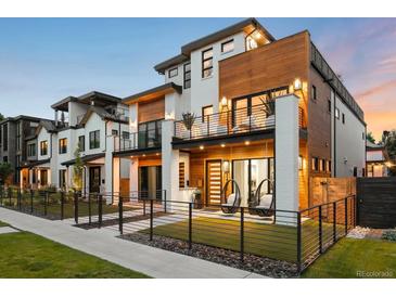 Modern exterior with white brick, wood accents, balconies, fenced yard, and hanging chairs at 340 Milwaukee St, Denver, CO 80206