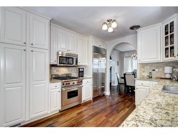 Kitchen showcases stainless steel Wolf range, microwave, refrigerator, and custom cabinets with hardwood floors at 1317 S Saint Paul St, Denver, CO 80210