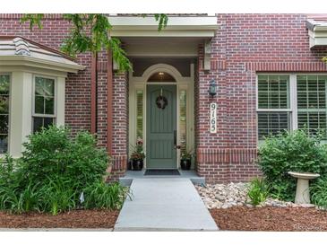 Close-up of the charming brick home showcasing the front door and well-maintained landscaping at 9165 Kornbrust Dr, Lone Tree, CO 80124