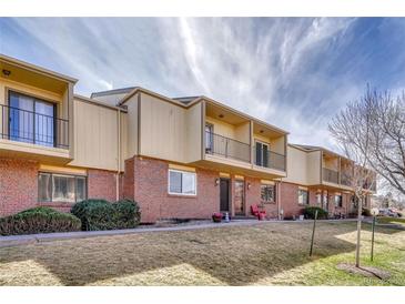 Townhome exterior with brick facade, balconies, manicured lawn, and community landscaping at 750 Tabor St # 46, Lakewood, CO 80401