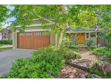 Charming home featuring a two-car garage, lush landscaping, and a brick walkway leading to the front door at 3966 Bosque Ct, Boulder, CO 80301