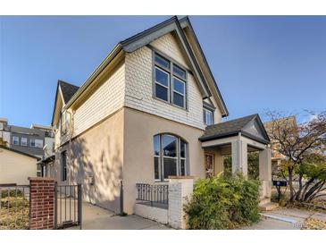 Charming two-story home with a brick fence and landscaped yard at 1839 Grove St, Denver, CO 80204