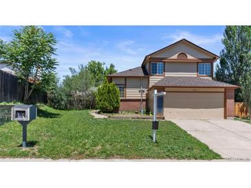Two-story home with a two-car garage, brick and siding exterior, and front lawn at 19937 E Loyola Pl, Aurora, CO 80013