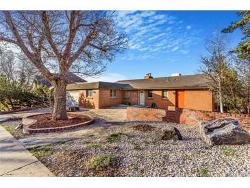 Charming brick home featuring a beautifully landscaped front yard and walkway at 14091 W Exposition Dr, Lakewood, CO 80228