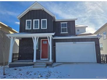Charming two-story home boasts a modern design, complemented by a bright red door and a spacious two car garage at 8820 Whiteclover St, Littleton, CO 80125