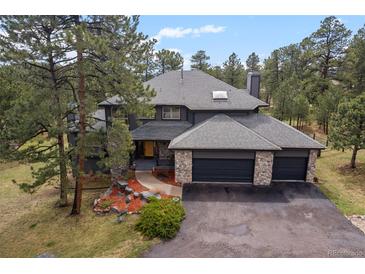 Charming two-story home featuring a three-car garage and professionally landscaped yard at 1423 Belford Ct, Evergreen, CO 80439