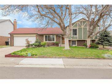 Charming front yard with mature trees and a well-maintained lawn enhance this home's curb appeal at 14867 E Harvard Ave, Aurora, CO 80014